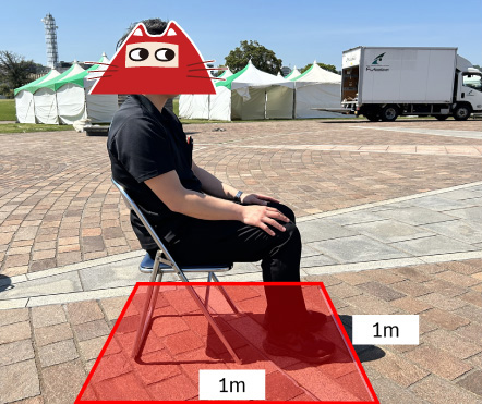 パイプ椅子に着席する男性を横から見た構図。1m四方。