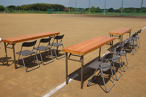 テーブル席。長テーブルにパイプ椅子が3脚ずつ並べられている。