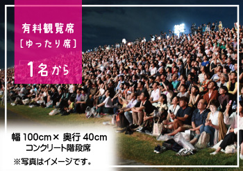 階段席／ゆったり席イメージ。多くの人が階段席に座っている。